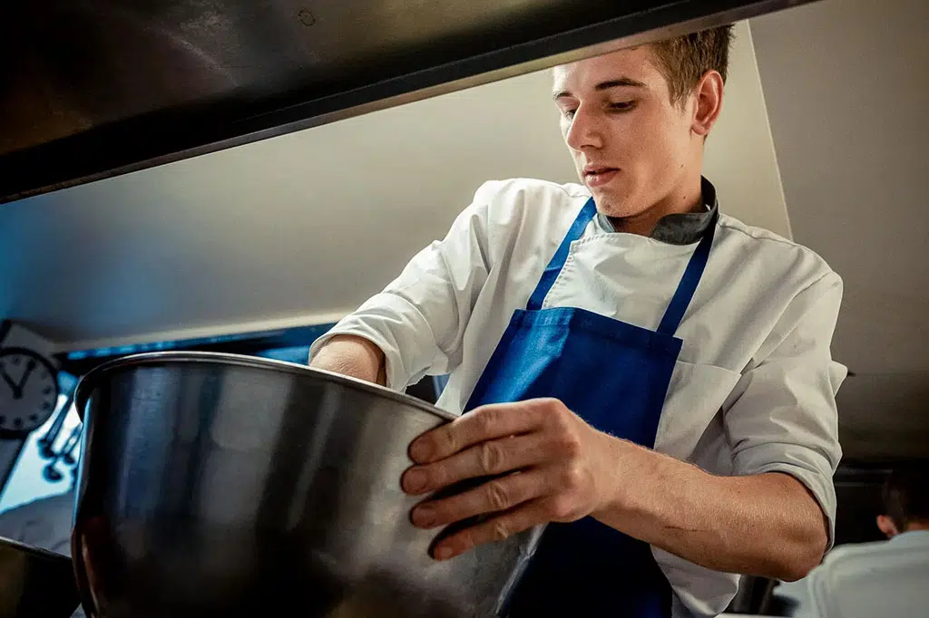 Corporate Photography Feature in Paris — Young chef in a professional kitchen preparing a dish, restaurant photography — Guillaume Galmiche